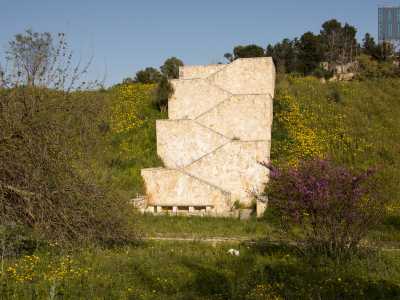 Incastonata nelle pareti calcaree di colore rossiccio spicca una massiccia scalinata in pietra bianca...